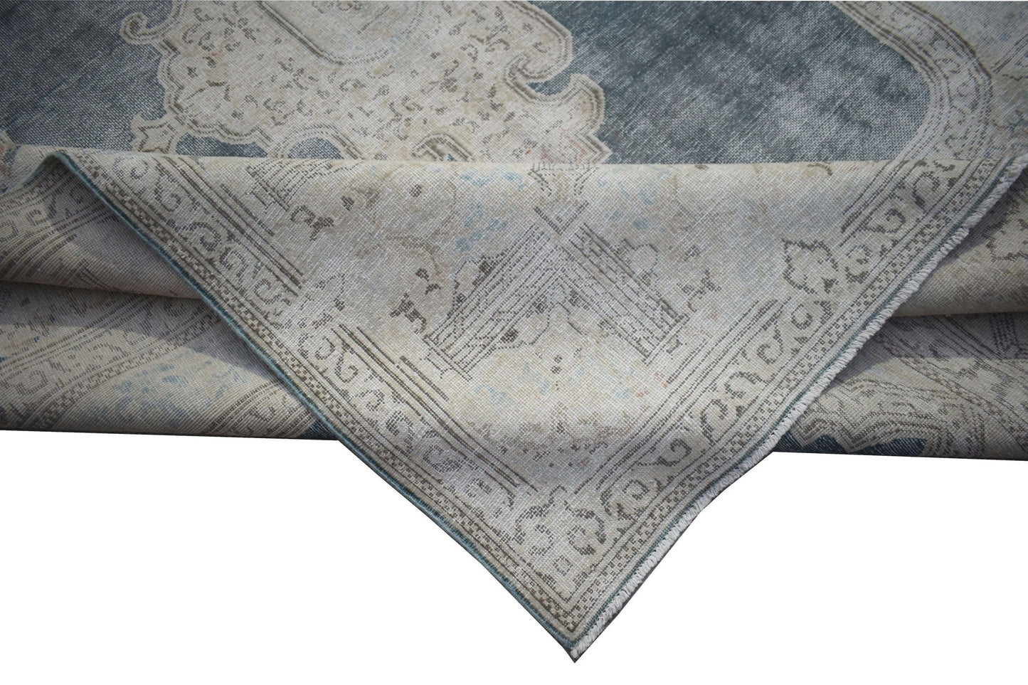 A vintage Persian Kerman rug featuring a blue and beige floral medallion design.