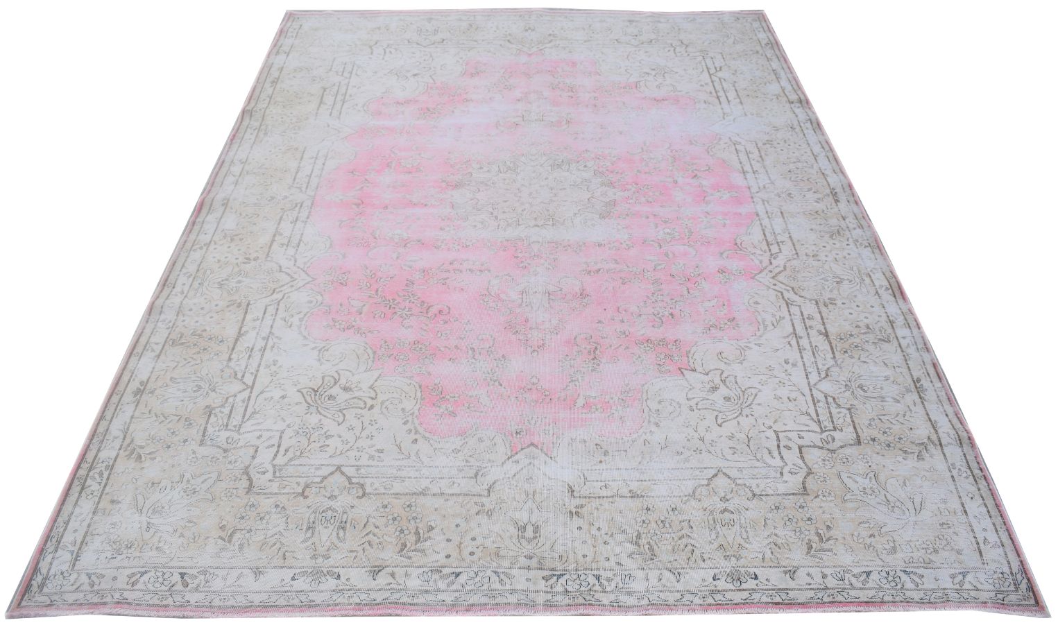 A vintage Persian Kerman rug featuring a central pink medallion and intricate floral patterns.