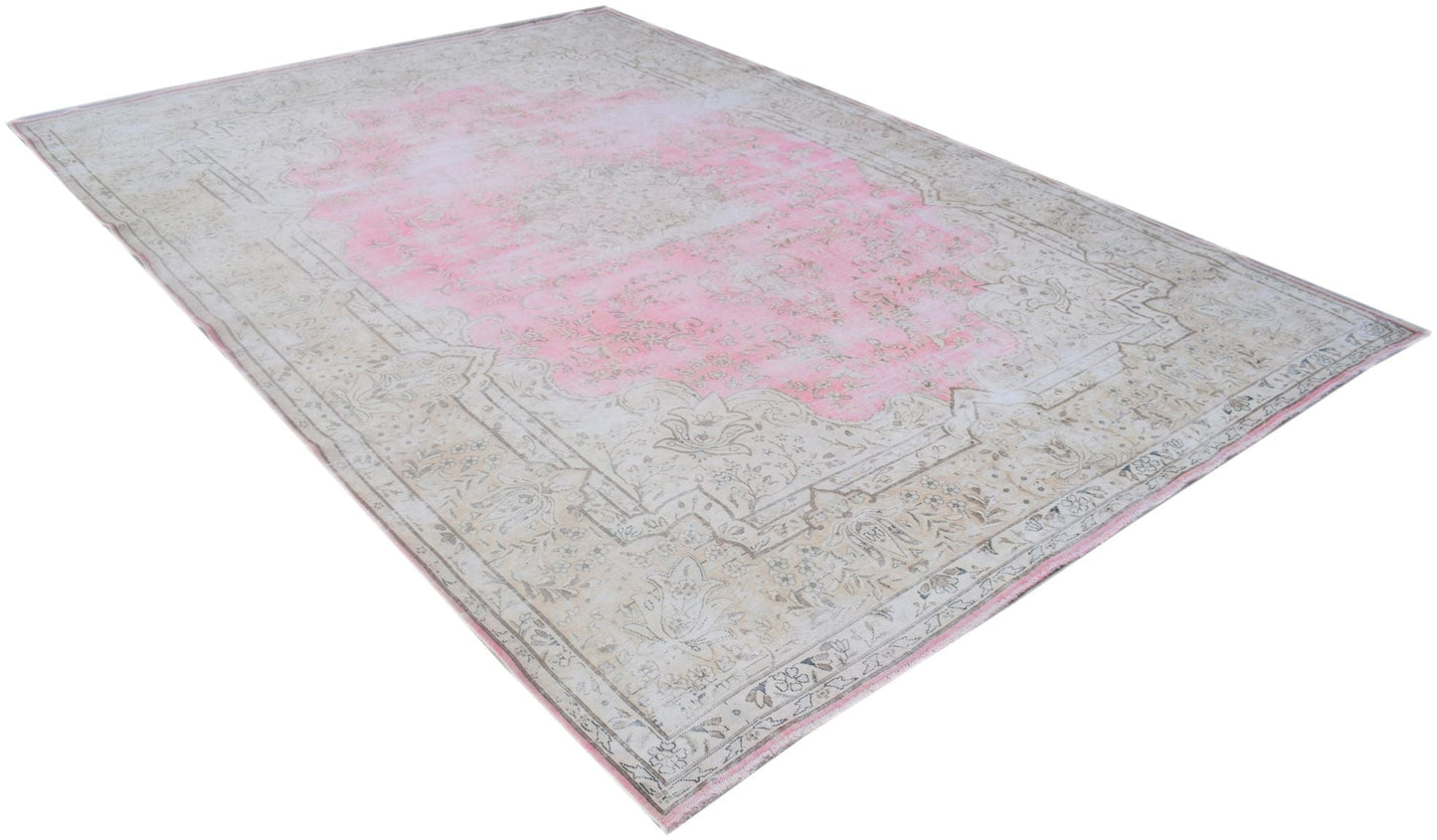 A vintage Persian Kerman rug featuring a faded pink central medallion and intricate floral borders.