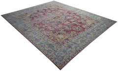 A vintage Persian Kerman rug featuring a red field with intricate floral patterns and a blue border.