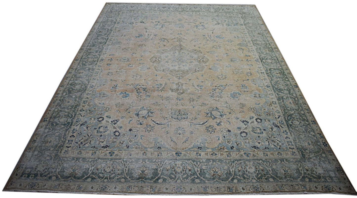 A vintage Persian Kerman rug featuring a central medallion and intricate floral patterns in blue.