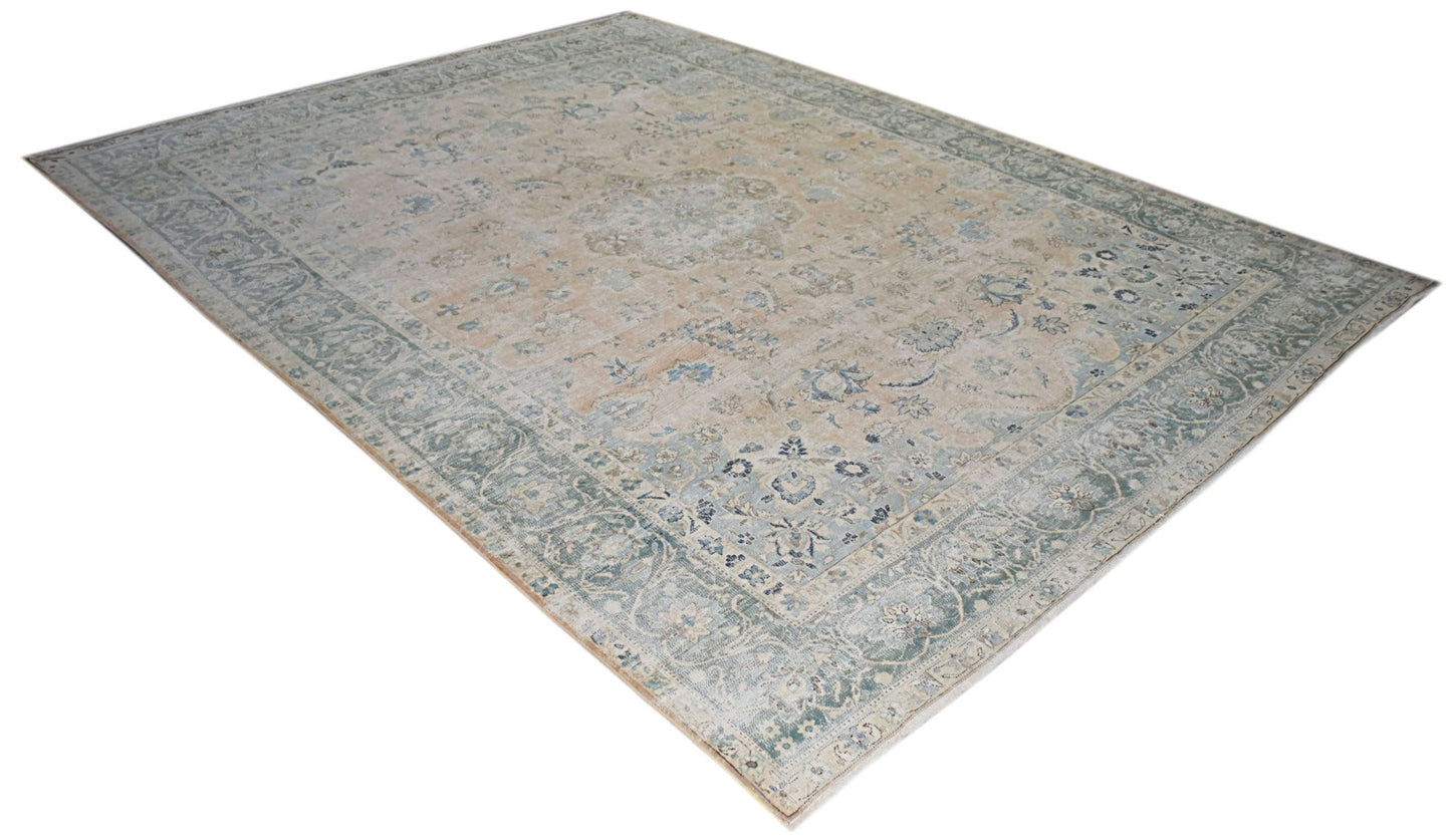 A vintage Persian Kerman rug featuring a central medallion and intricate floral patterns in blue.