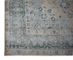 A vintage Persian Kerman rug featuring a faded blue and beige floral pattern with a wide border.