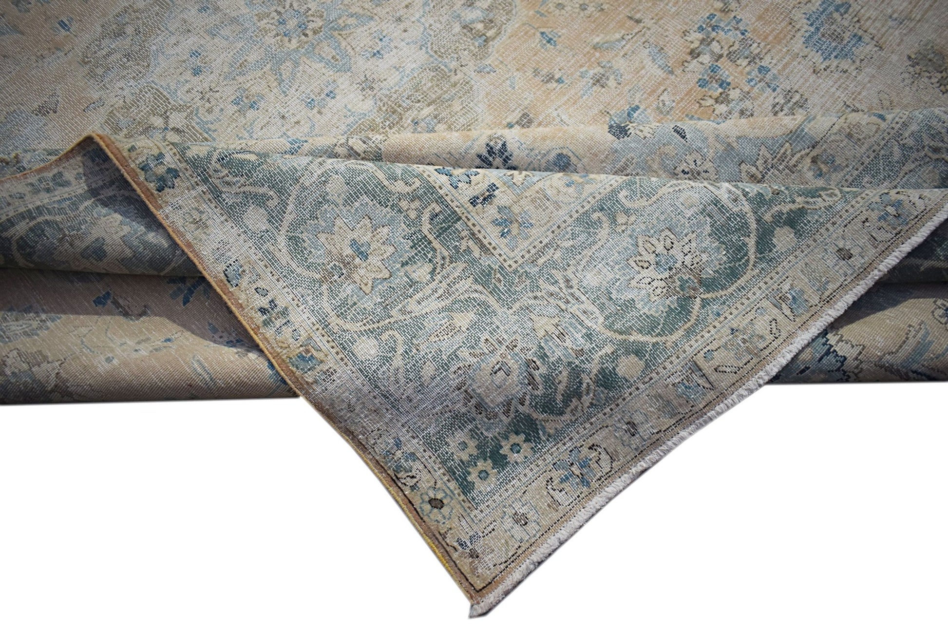 A vintage Persian Kerman rug featuring a faded floral medallion design in blue and beige tones.