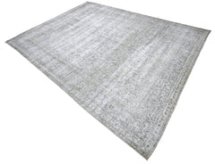 Vintage Persian Kerman rug with a faded grey and blue intricate floral pattern and a low-pile wool finish.