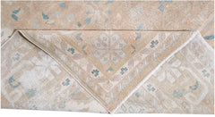 A vintage Persian Kerman rug featuring a soft beige palette with intricate floral medallion motifs.