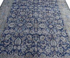 A vintage Persian Kerman rug featuring an intricate blue and cream floral pattern.