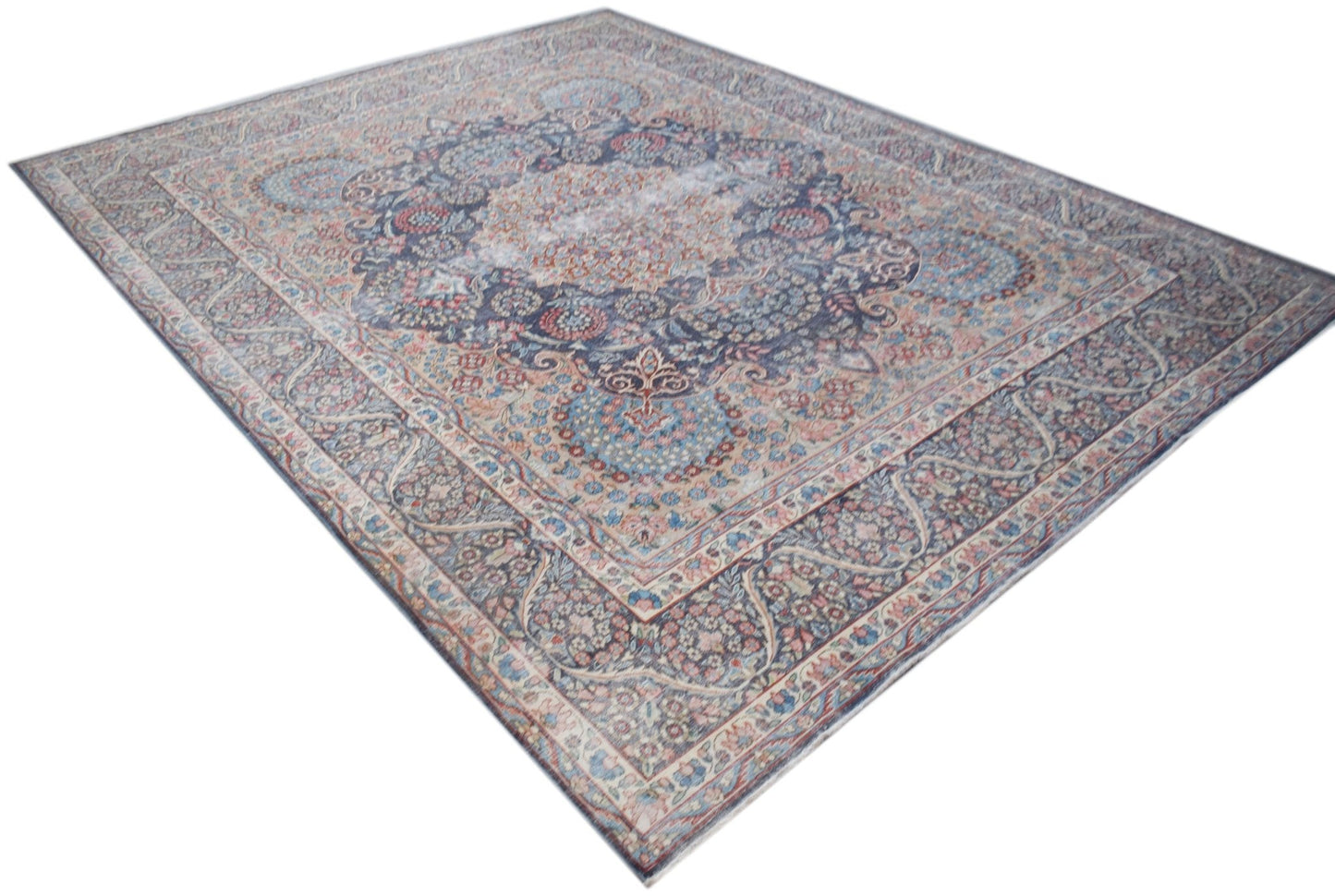 A vintage Persian Kerman rug featuring an intricate floral medallion design in muted blue tones.