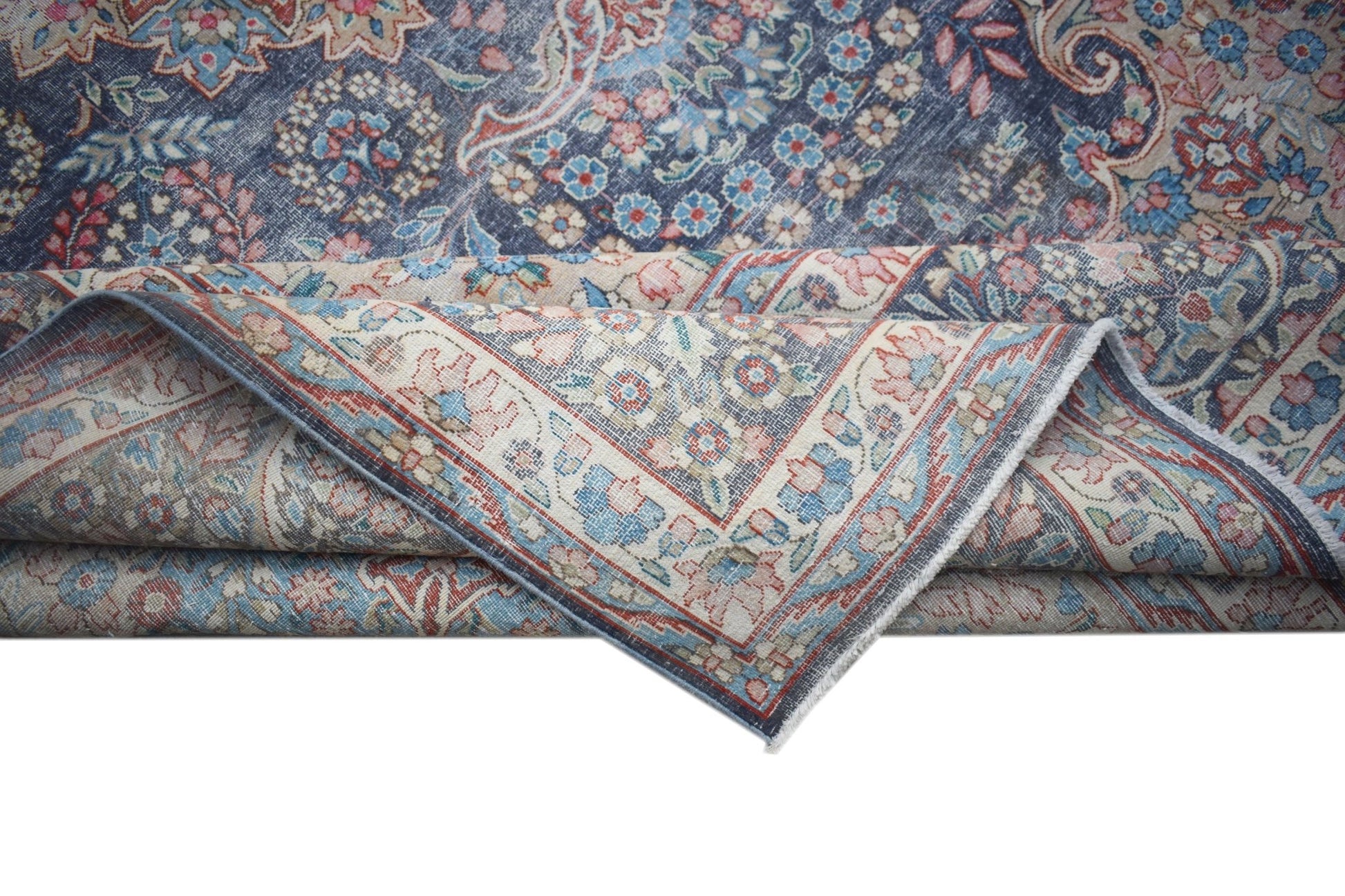 A vintage Persian Kerman rug featuring a blue field with intricate floral patterns and a border.