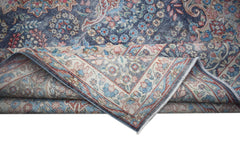 A vintage Persian Kerman rug featuring a blue field with intricate floral patterns and a border.