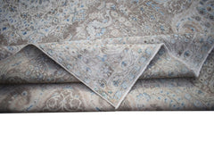 A vintage Persian Kerman rug featuring a detailed floral medallion pattern in soft blue and beige.