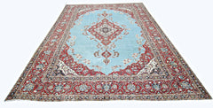 A vintage Persian Kerman rug featuring a central medallion on a light blue field with floral motifs.