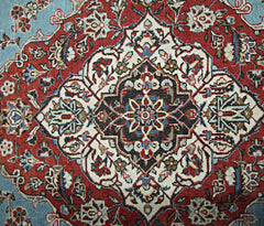 A vintage Persian Kerman rug featuring an intricate central medallion with floral motifs.