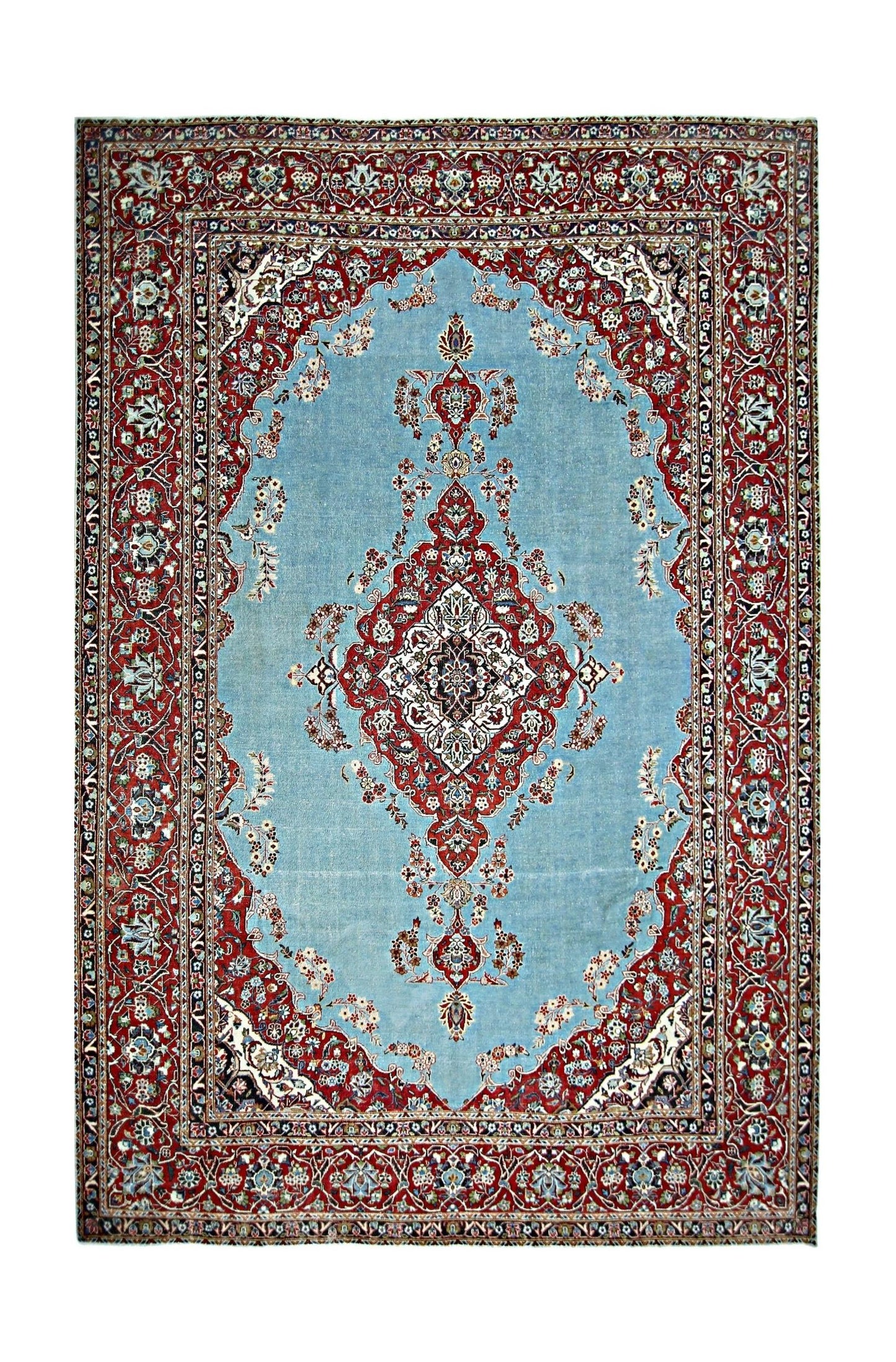 A vintage Persian Kerman rug featuring a central floral medallion on a light blue field.