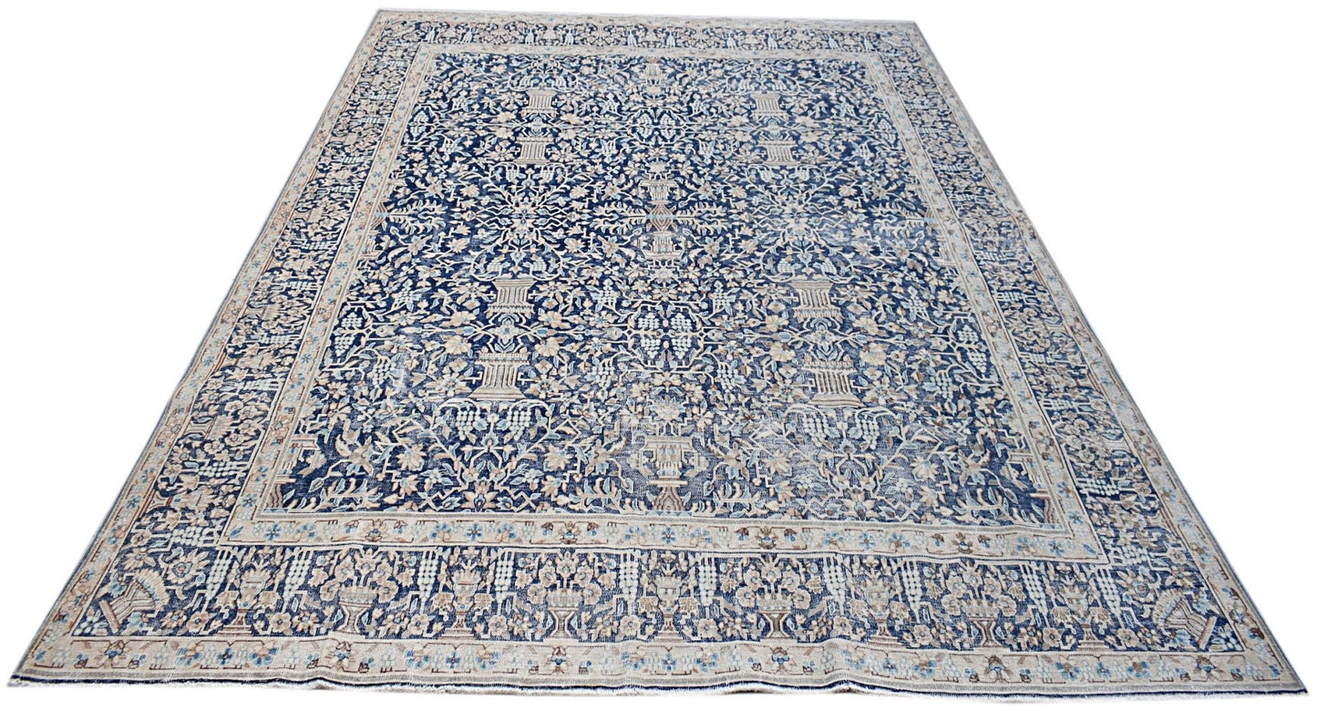 A vintage Persian Kerman rug featuring an intricate blue and cream floral pattern.