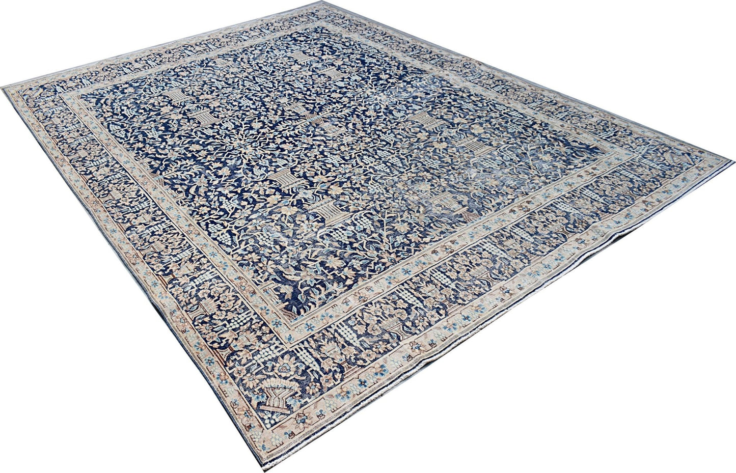 A vintage Persian Kerman rug featuring an intricate floral pattern in shades of blue and cream.
