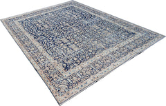 A vintage Persian Kerman rug featuring an intricate floral pattern in shades of blue and cream.