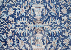 A vintage Persian Kerman rug featuring an intricate blue floral pattern with symmetrical motifs.