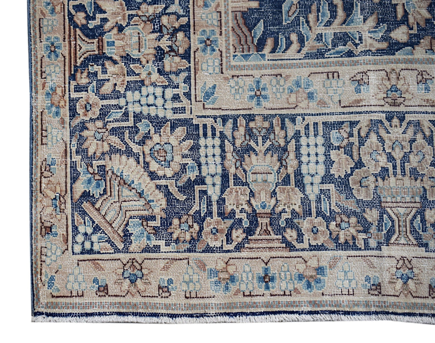 A vintage Persian Kerman rug featuring intricate floral patterns in shades of blue and beige.