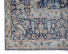 A vintage Persian Kerman rug featuring intricate floral patterns in shades of blue and beige.