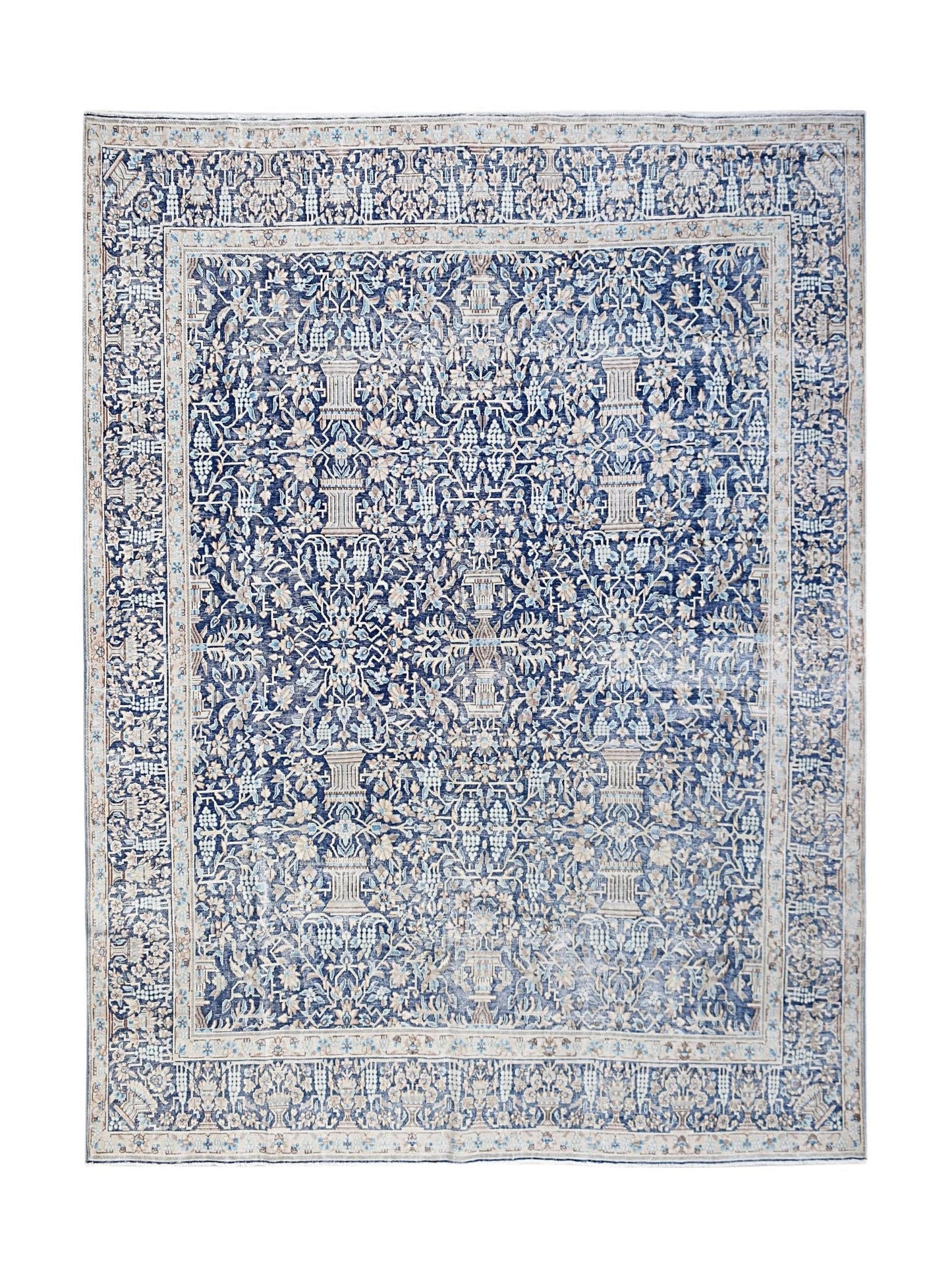 A vintage Persian Kerman rug featuring an intricate blue and cream floral pattern.
