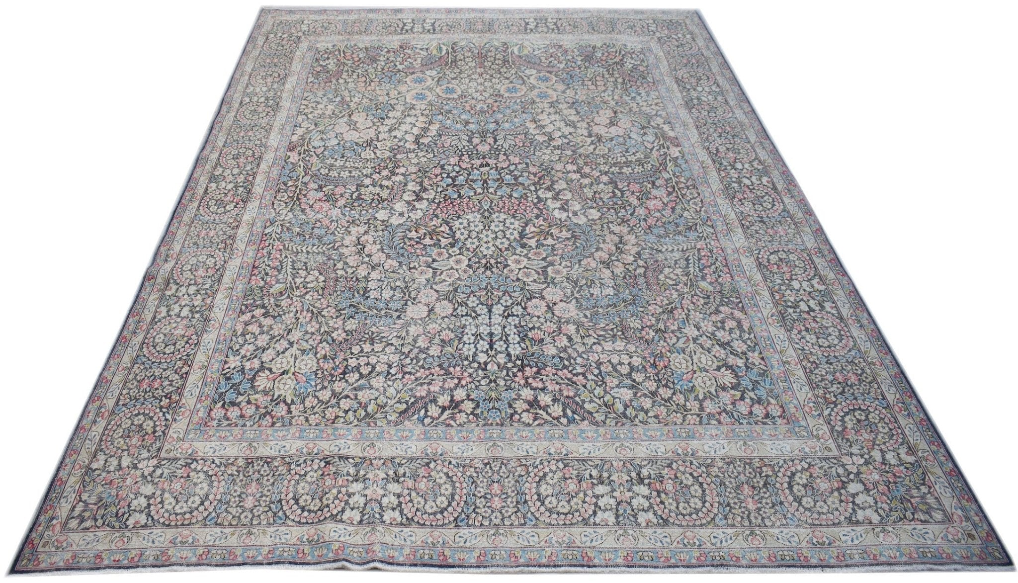 A vintage Persian Kerman rug featuring an intricate floral pattern and a central medallion.