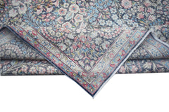 A vintage Persian Kerman rug featuring an intricate floral pattern in soft pink and blue tones.
