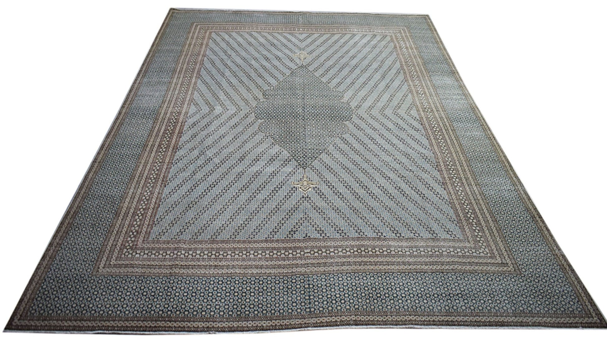 A vintage Persian Kerman rug featuring a central medallion and intricate geometric patterns.