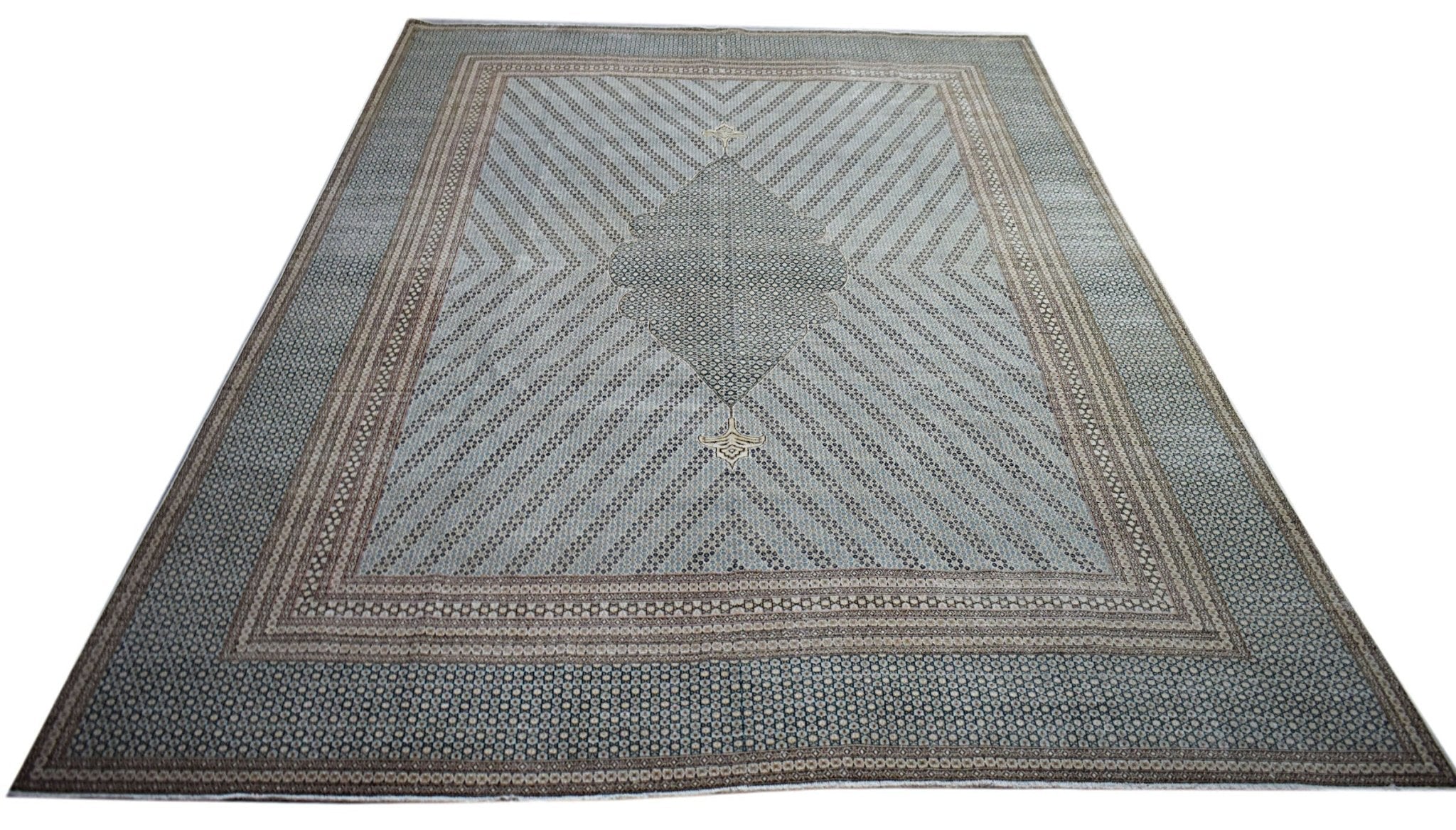 A vintage Persian Kerman rug featuring a central medallion and intricate geometric patterns.