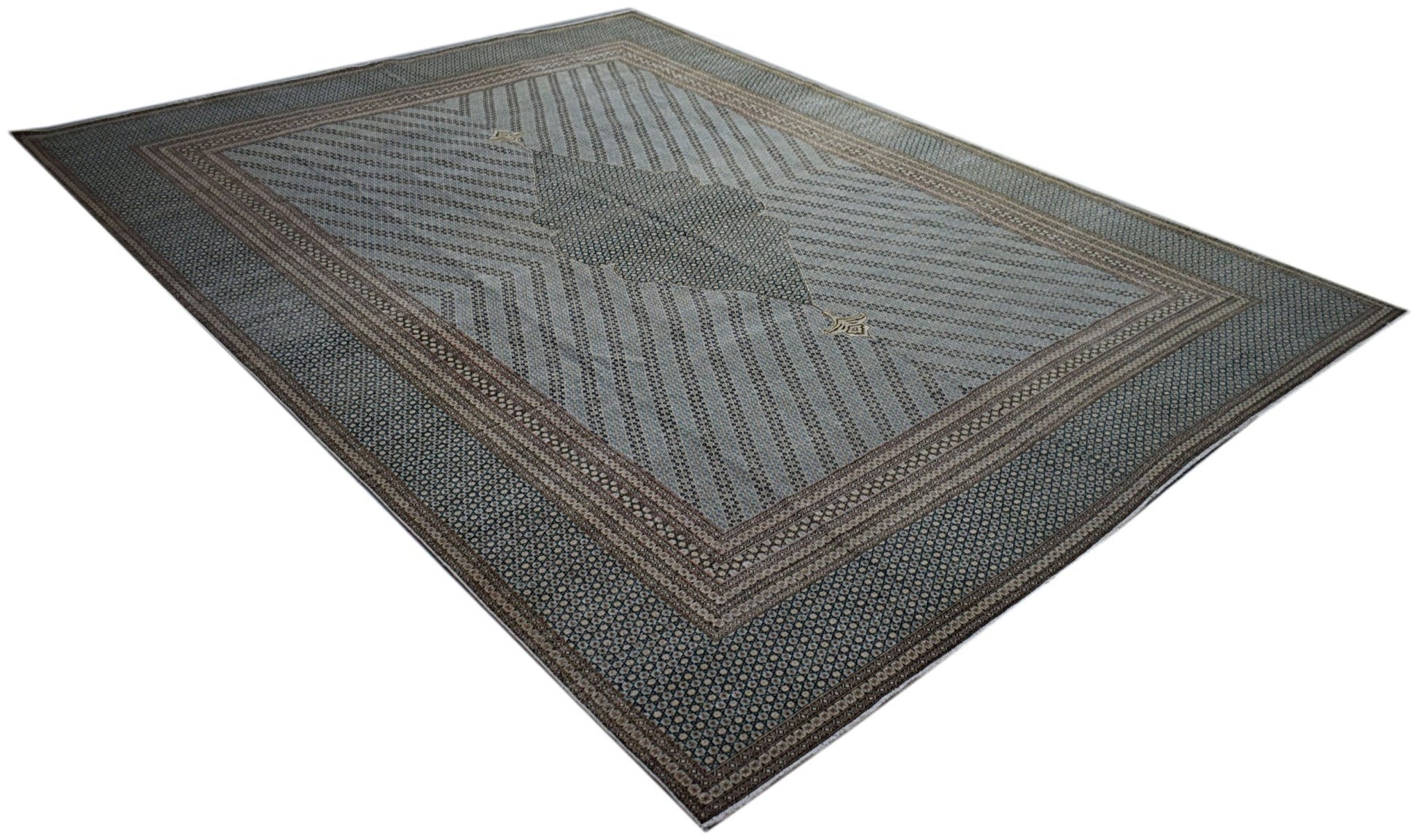 A vintage Persian Kerman rug featuring a central medallion and intricate geometric patterns.