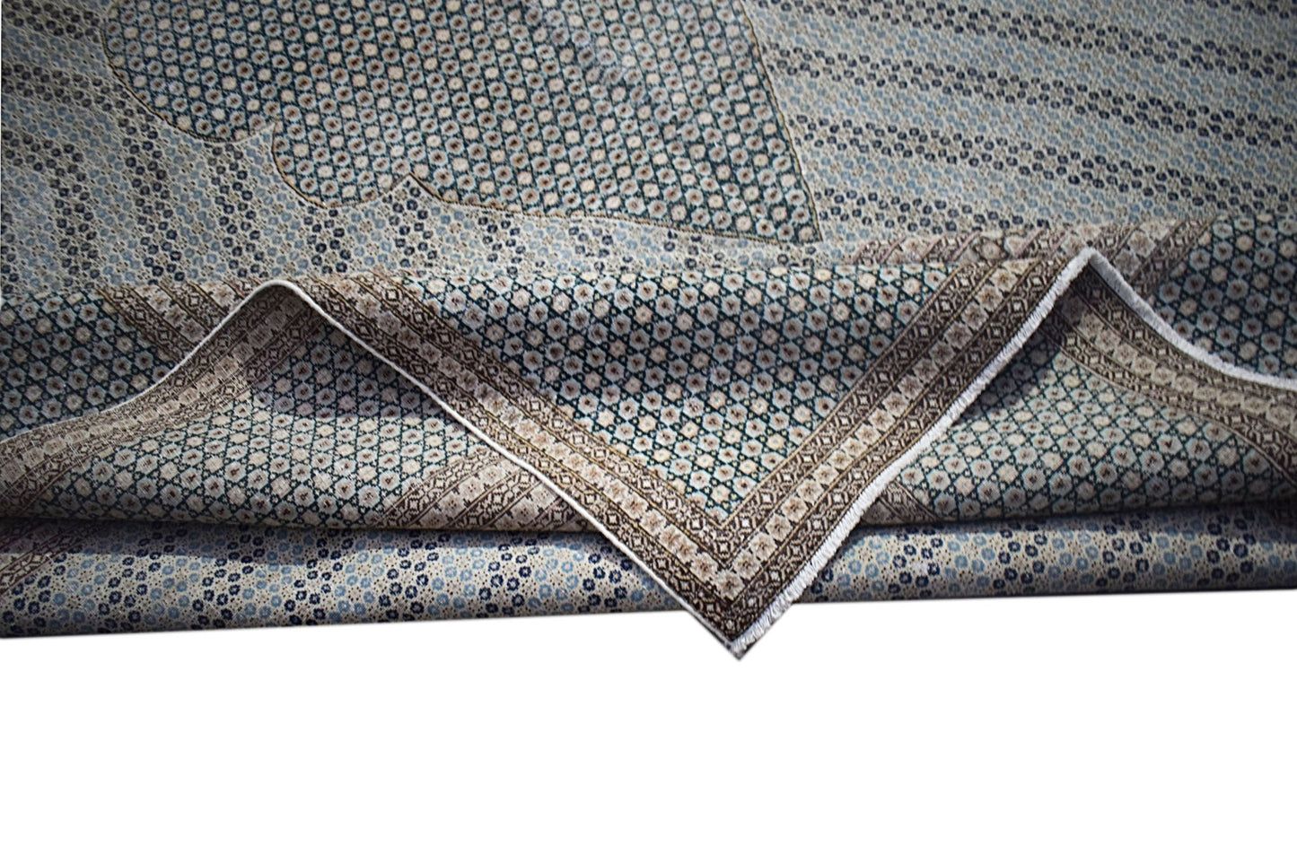 A vintage Persian Kerman rug featuring an intricate floral pattern and a folded corner.