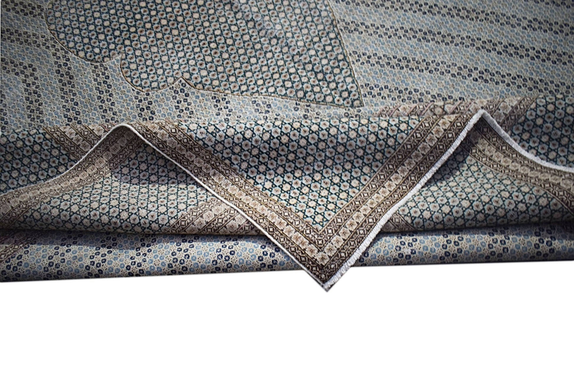 A vintage Persian Kerman rug featuring an intricate floral pattern and a folded corner.