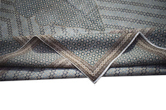 A vintage Persian Kerman rug featuring an intricate floral pattern and a folded corner.