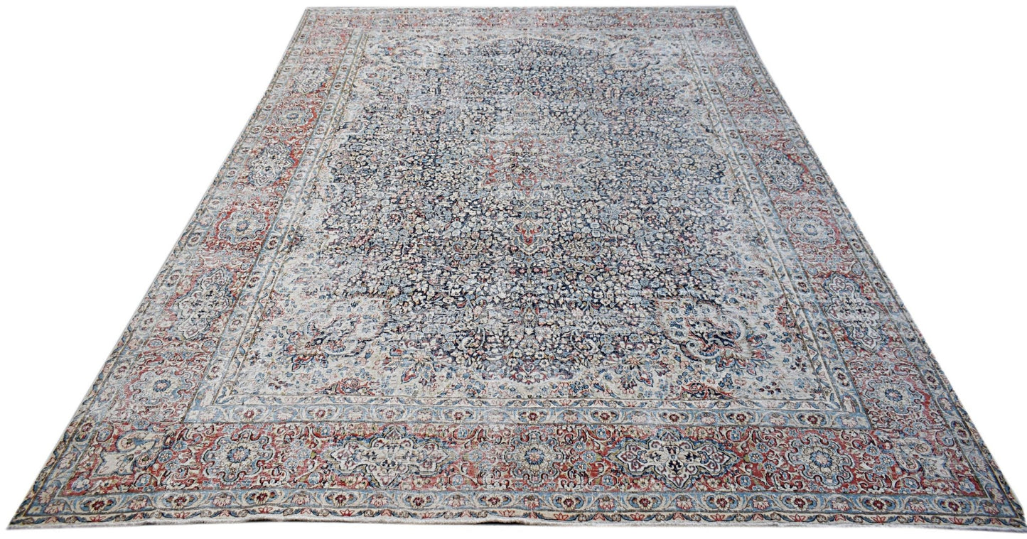 A vintage Persian Kerman rug featuring an intricate floral medallion design in blue and red tones.