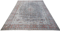 A vintage Persian Kerman rug featuring an intricate floral medallion design in blue and red tones.