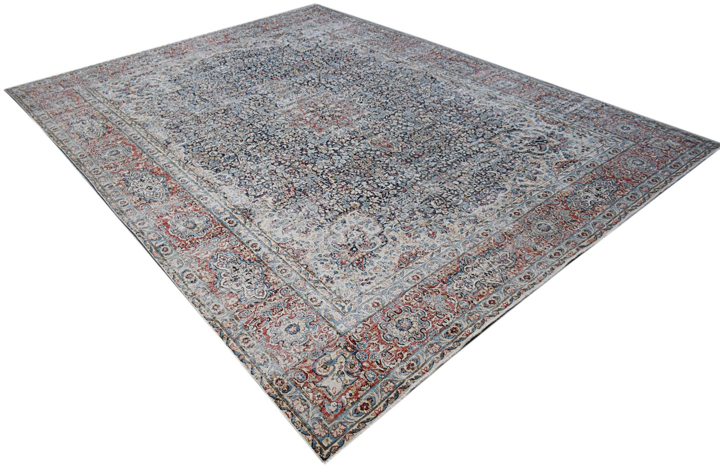 A vintage Persian Kerman rug featuring an intricate floral medallion design in blue and red tones.