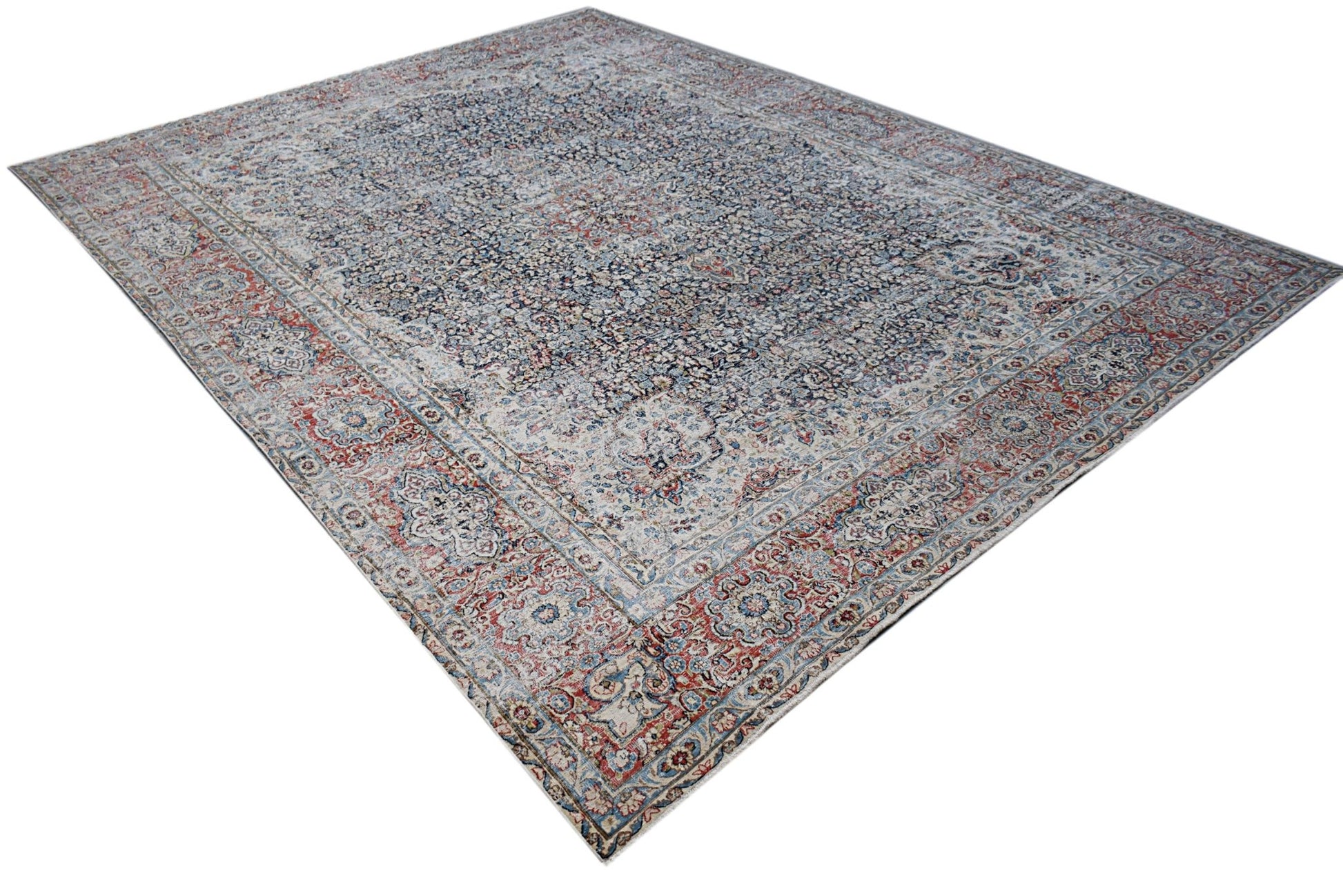 A vintage Persian Kerman rug featuring an intricate floral medallion design in blue and red tones.