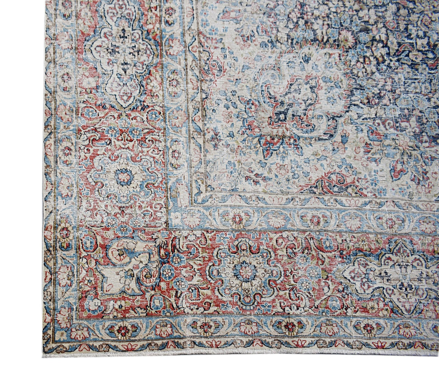 A vintage Persian Kerman rug featuring an intricate floral medallion design in red and blue tones.