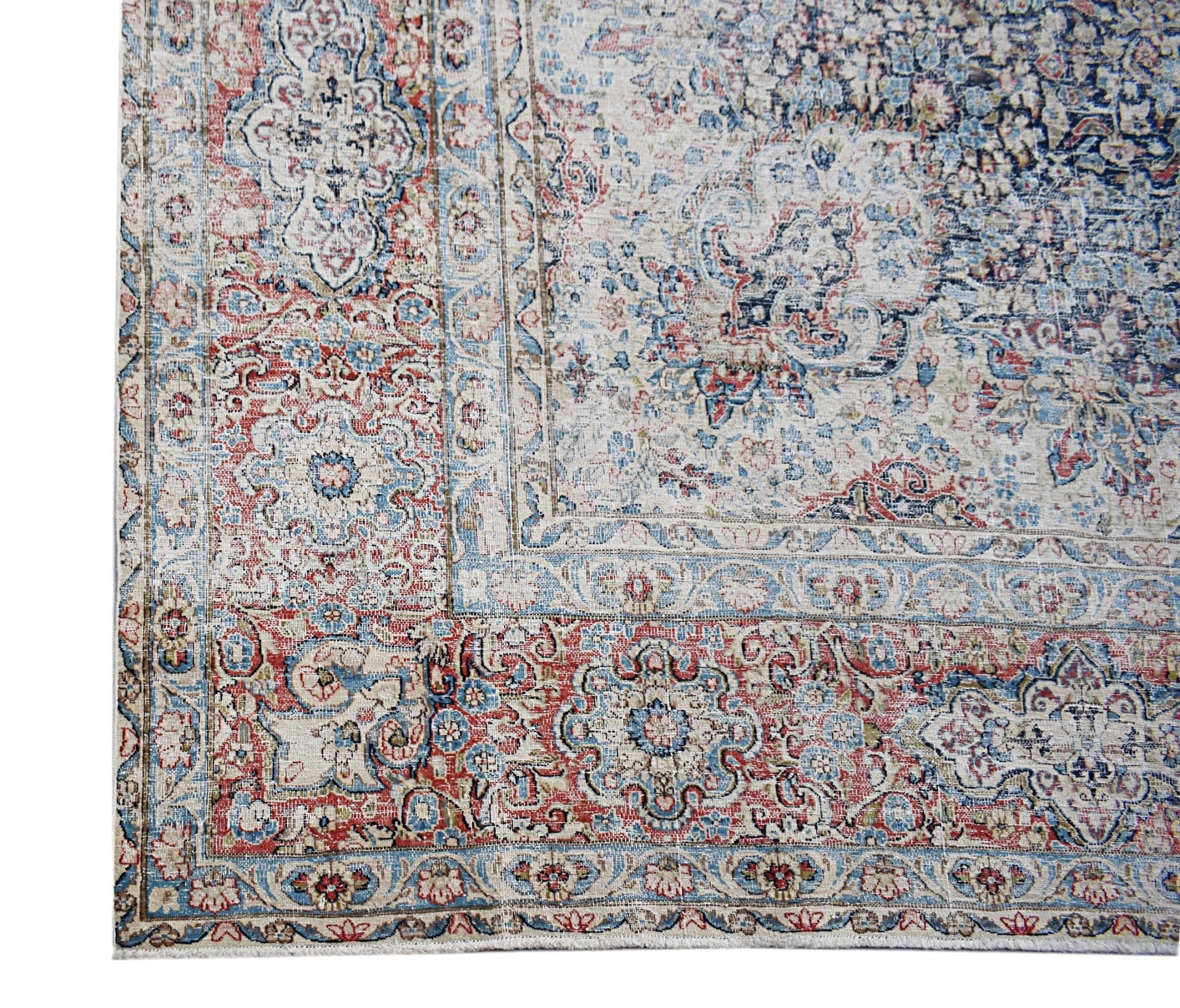 A vintage Persian Kerman rug featuring an intricate floral medallion design in red and blue tones.