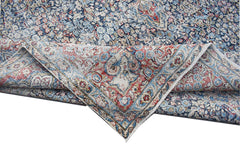 A vintage Persian Kerman rug featuring an intricate floral medallion pattern in blue and red.