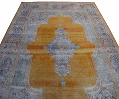 A vintage Persian Kerman rug featuring a central medallion on a golden field with floral borders.