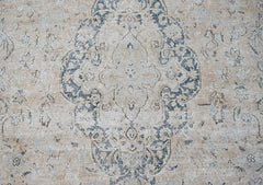 A vintage Persian Kerman rug featuring a central medallion with intricate floral motifs in blue.