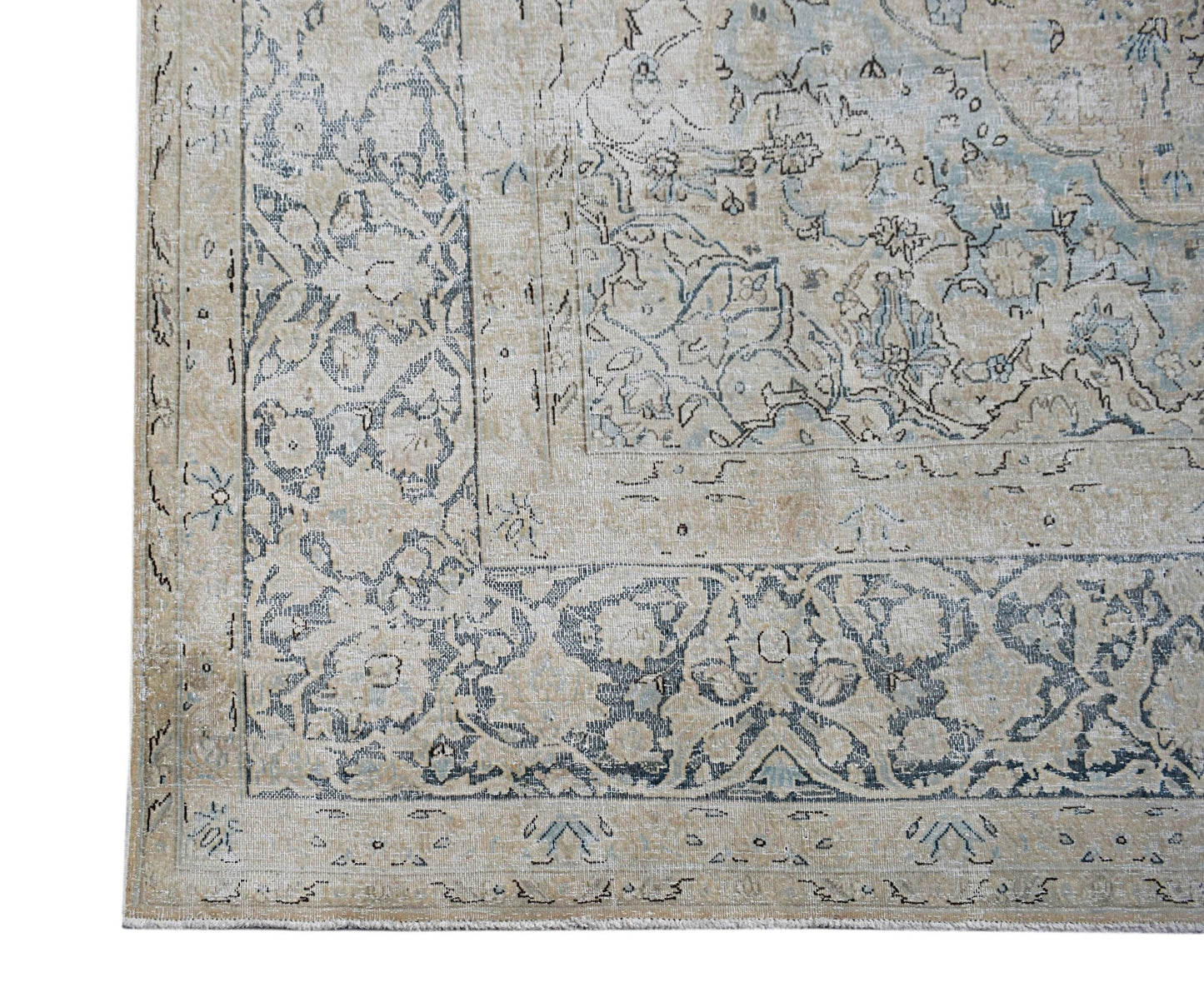 A vintage Persian Kerman rug featuring intricate floral patterns in muted blue and beige tones.