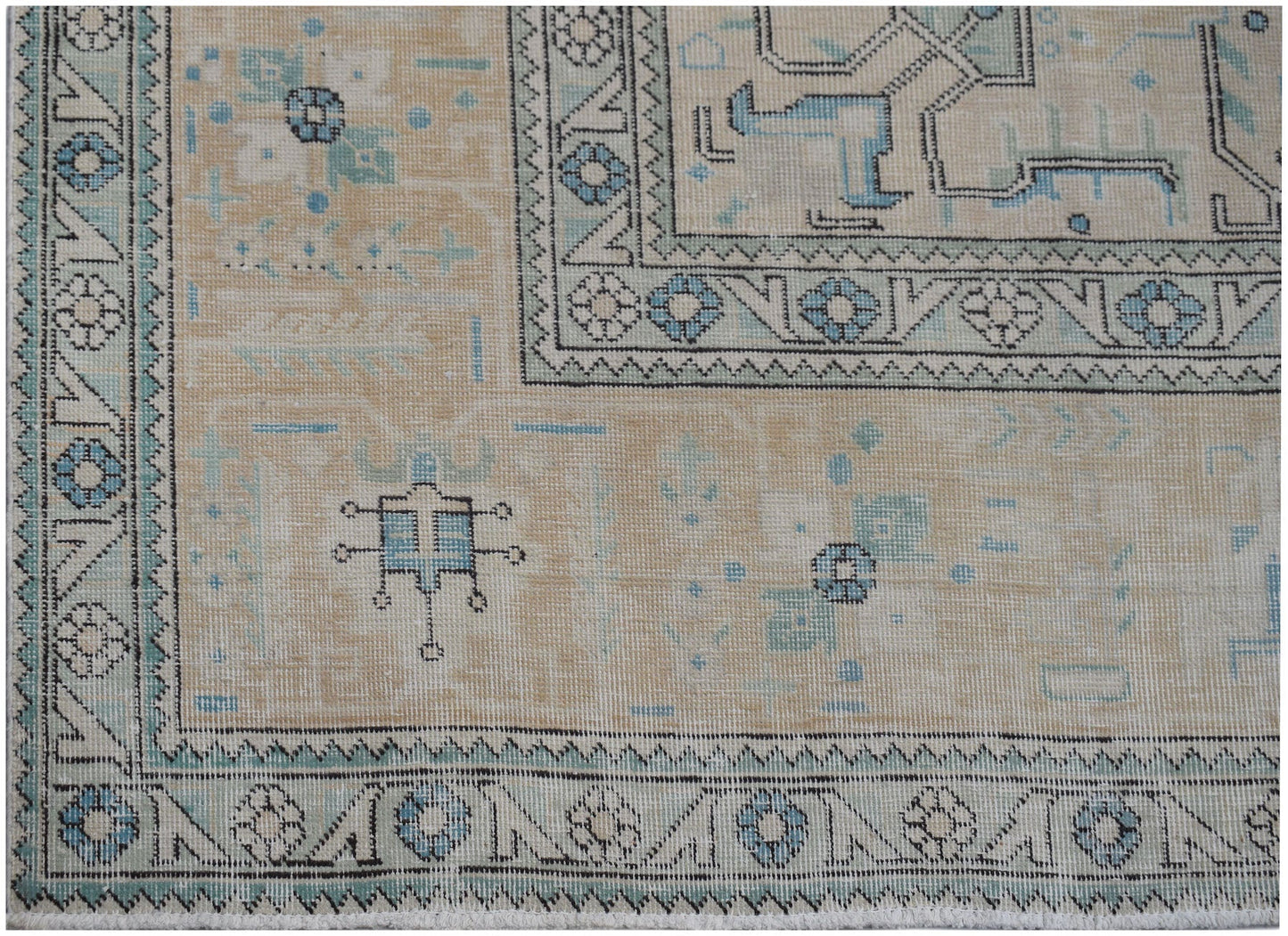 A vintage Persian Kerman rug featuring intricate blue and beige floral and geometric patterns.