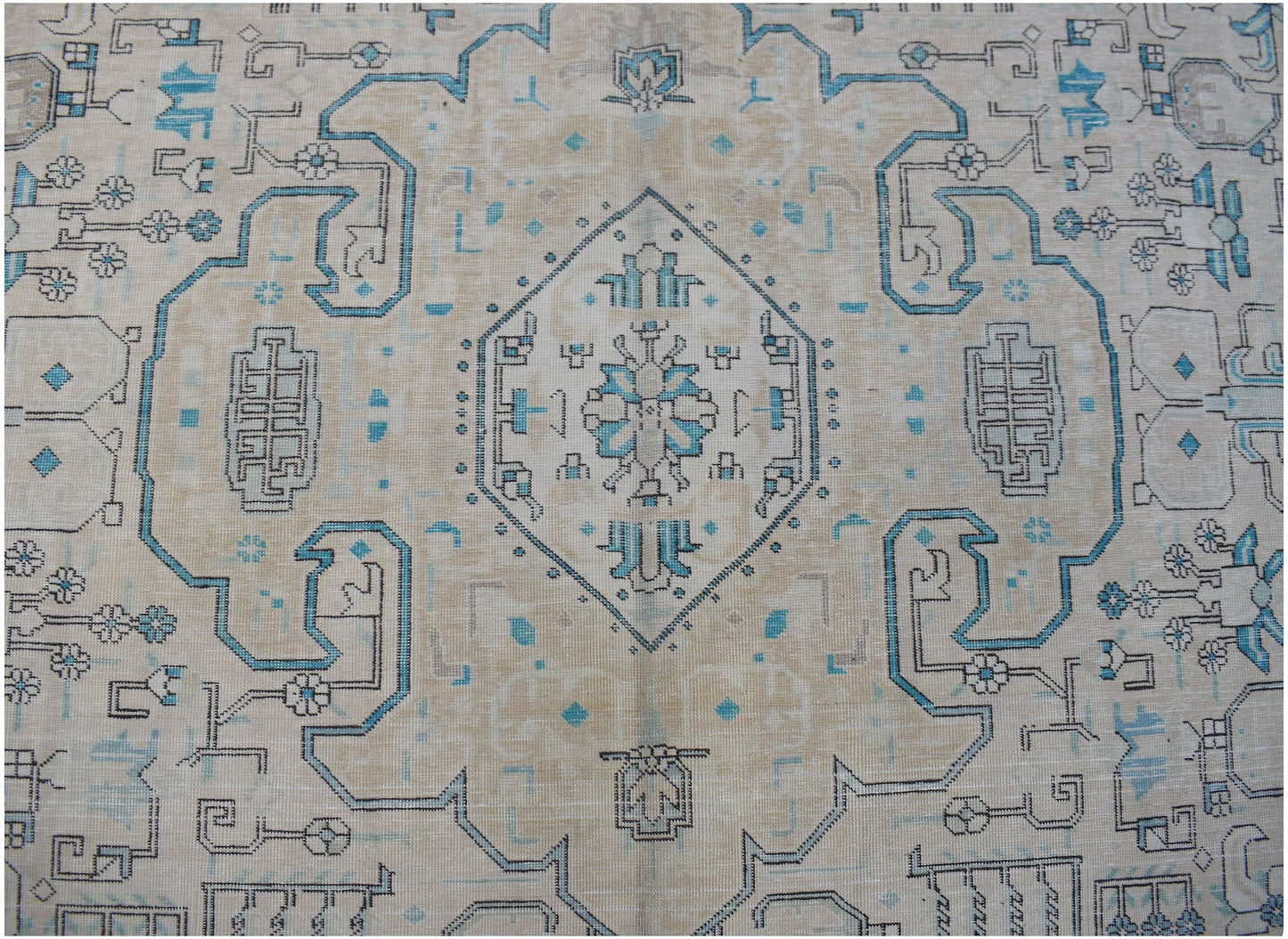 A vintage Persian Kerman rug featuring a central medallion with intricate blue and beige patterns.