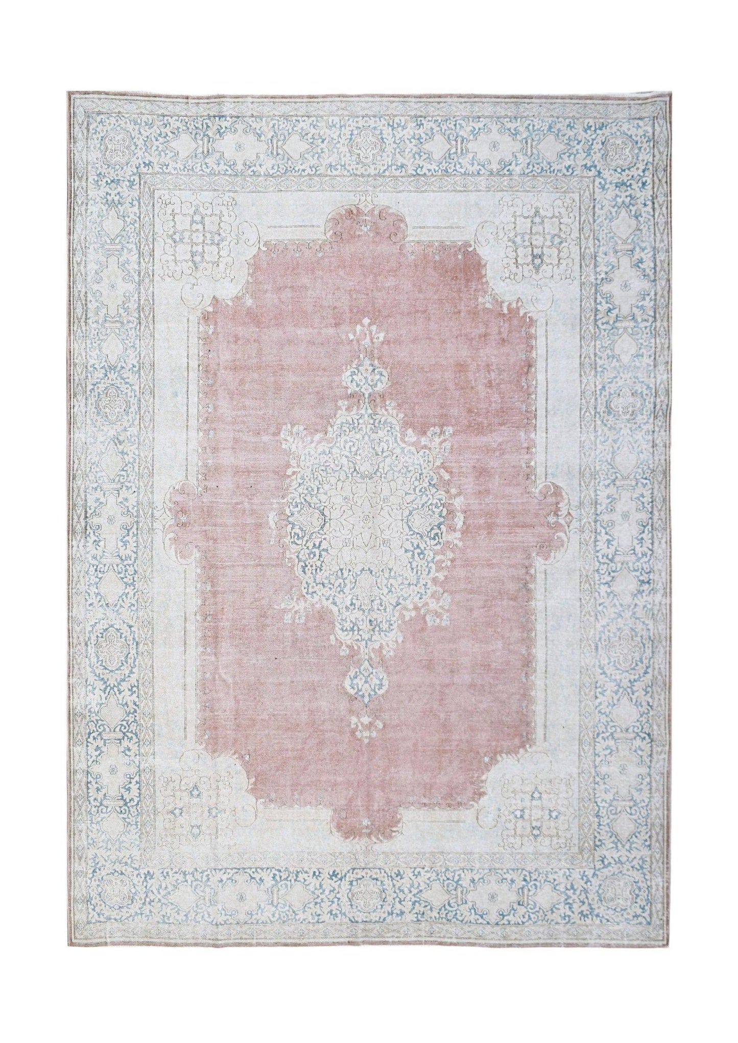 A vintage Persian Kerman rug featuring a central medallion in soft pink and blue floral patterns.