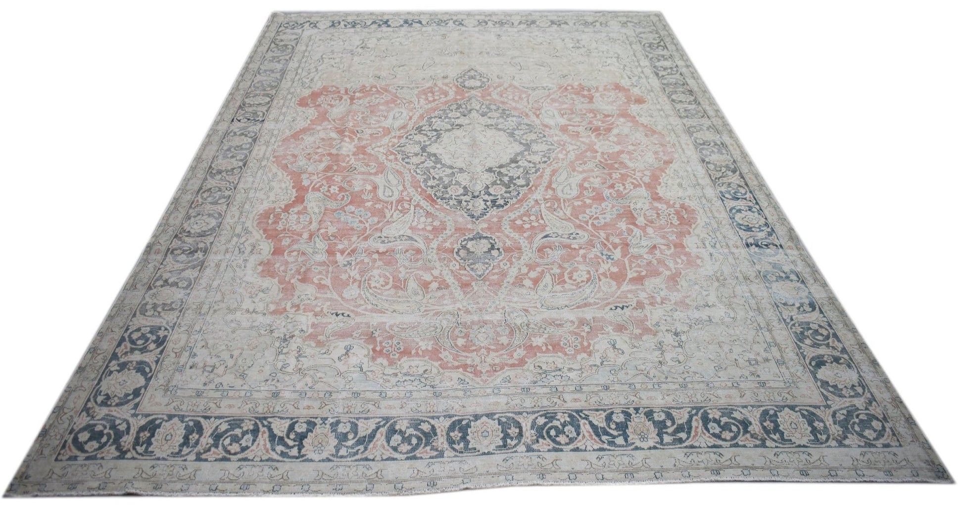 A vintage Persian Kerman rug featuring a central medallion and intricate floral patterns.