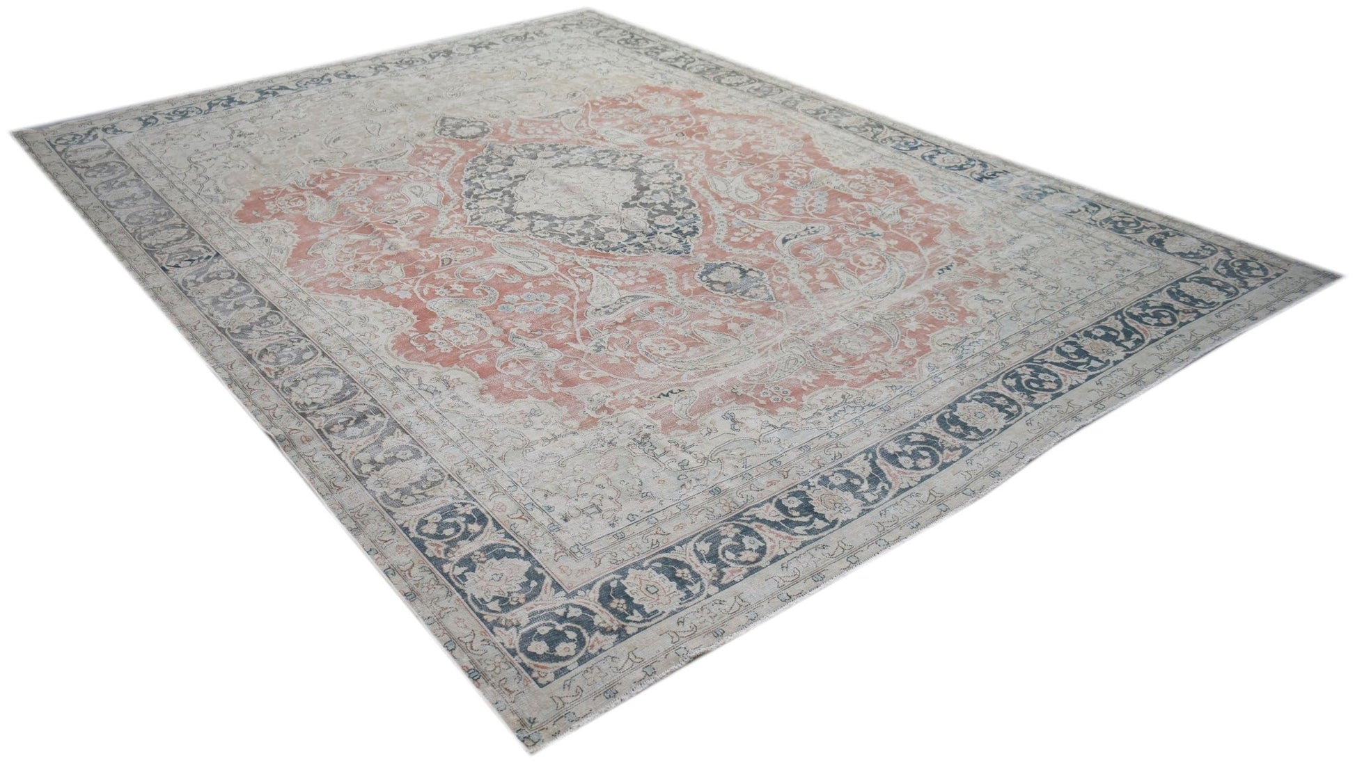A vintage Persian Kerman rug featuring a central medallion and floral motifs in muted tones.