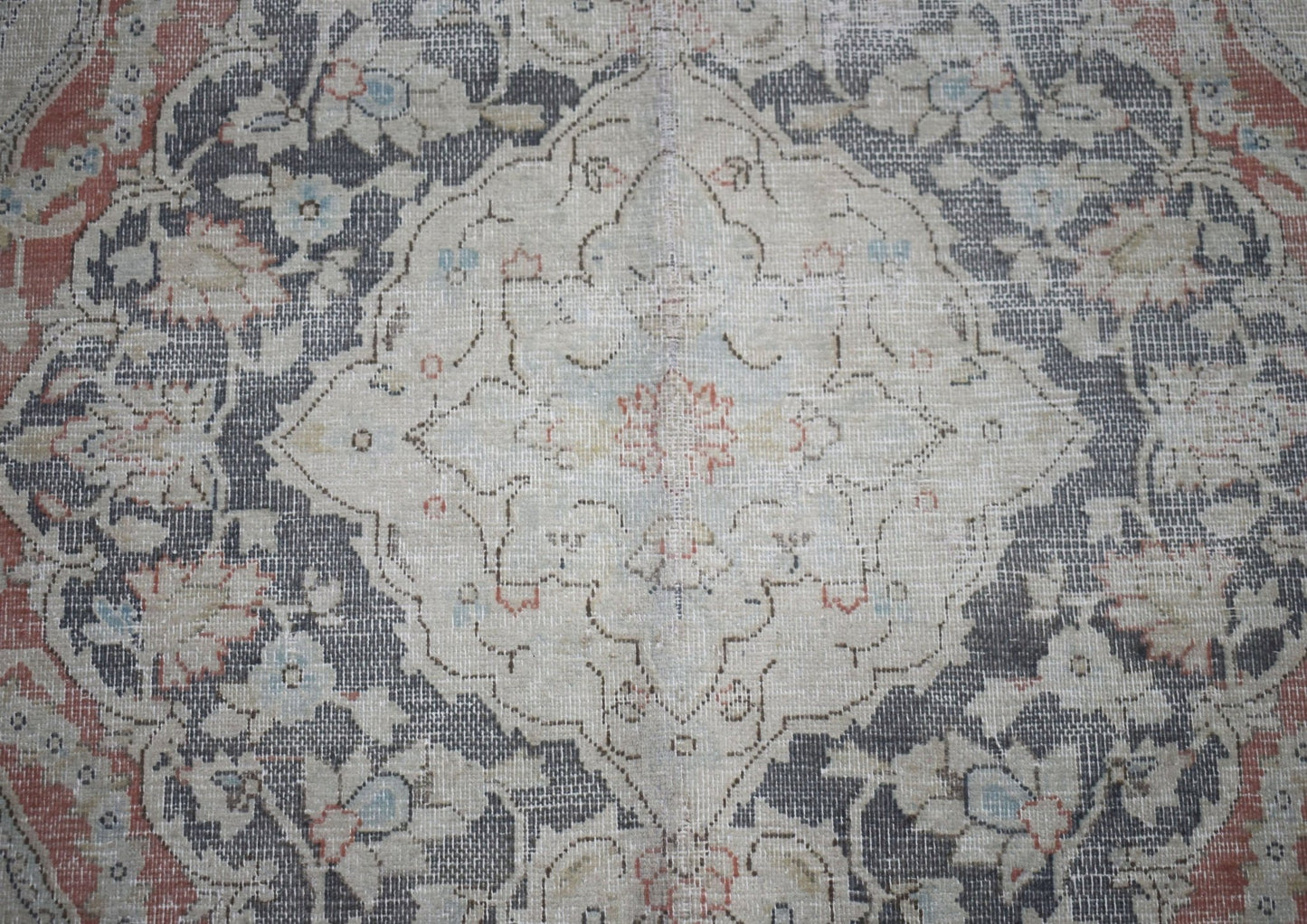 A vintage Persian Kerman rug featuring a central medallion surrounded by intricate floral patterns.