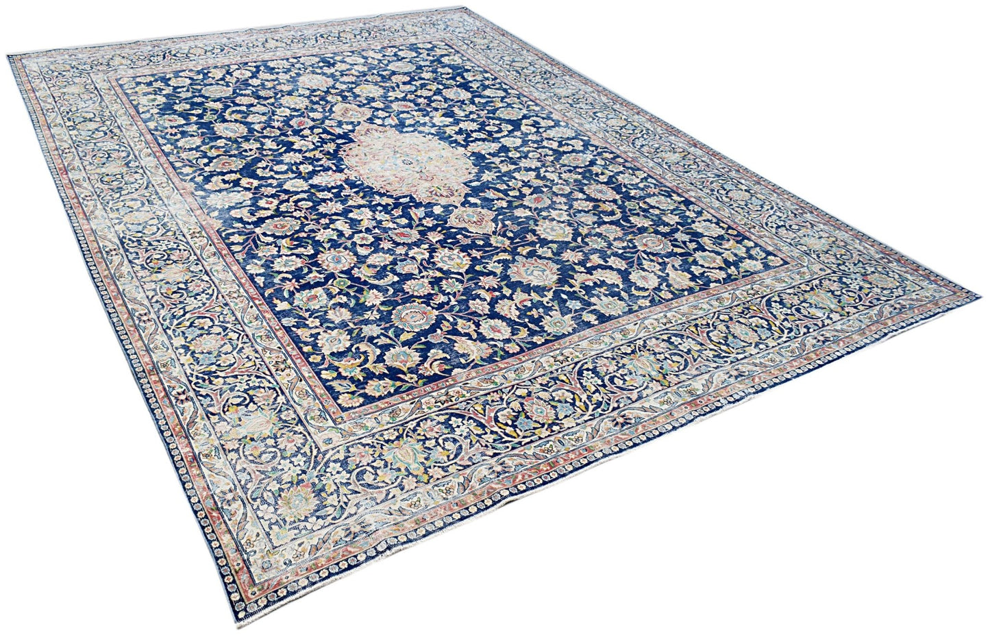A vintage Persian Kerman rug featuring an intricate floral pattern and a central medallion.